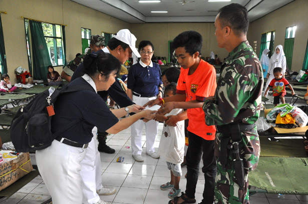 Relawan Tzu Chi memberikan uang satunan kepada keluarga yang menjadi korban jiwa akibat dari peristiwa banjir bandang di Garut.