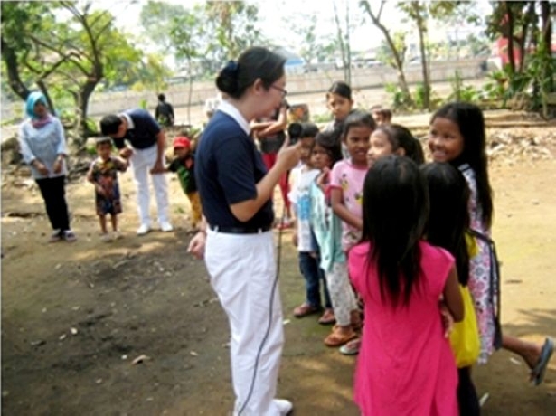 Joliana, salah satu relawan Tzu Chi menghibur para penghuni Rumah Belajar Anak Langit dengan kisah yang bertemakan anak katak dan anak lembu.