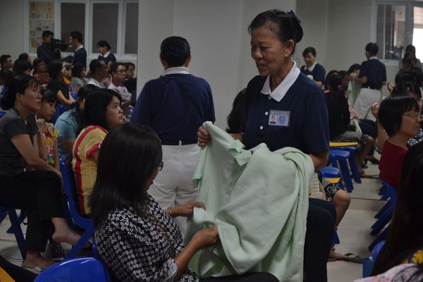 Relawan Tzu Chi menunjukkan barang-barang  hasil daur ulang botol plastik kepada orang tua murid yang hadir dalam sosialisasi pelestarian lingkungan.