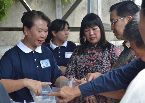Lu Lian Chu, Ketua Tzu Chi Tangerang (kiri) menjelaskan kepada guru dan orang tua murid jenis barang yang bisa didaur ulang dan yang tidak bisa.