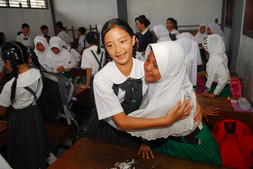 Ginny Tsai (12), murid kelas 5, SD Tzu Chi Hualien memeluk salah satu siswa MI (Madrasah Ibtidaniyah) sekolah Al-Mutaqin dalam sesi belajar bersama di kelas.
