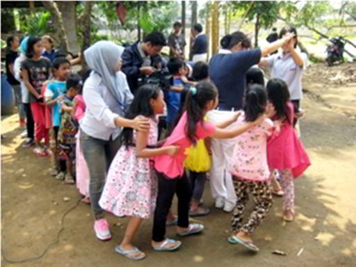 Anak-anak Rumah Belajar Anak Langit bermain permainan Ular Naga dengan para relawan Tzu Chi