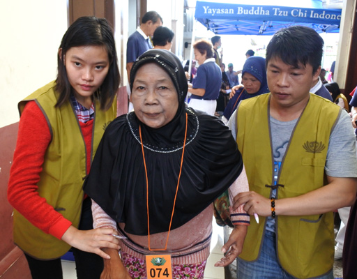 Indah dan Piter memapah Ibu Alfiah (60) menuju ke ruang pemeriksaan dokter.