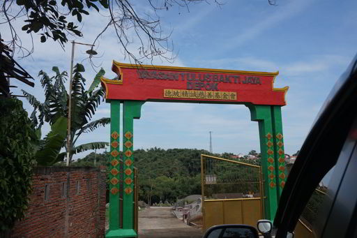 Relawan Tzu Chi menjenguk Aliong di tempat tinggalnya sekarang di Depok. Kondisi tempat tidurnya menghadap kuburan, sedangkan belakang bangunan adalah Sungai Ciliwung.