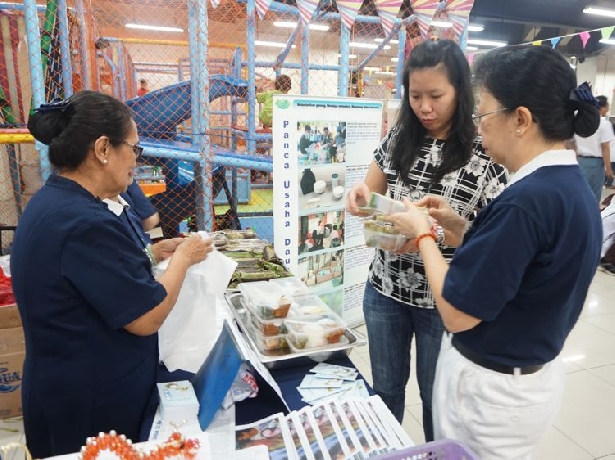 Insan Tzu Chi memperkenalkan makanan vegetarian Tzu Chi dan bercerita singkat tentang Tzu Chi kepada pengunjungi Gedung Pusat Grosir Cillitan (PGC).